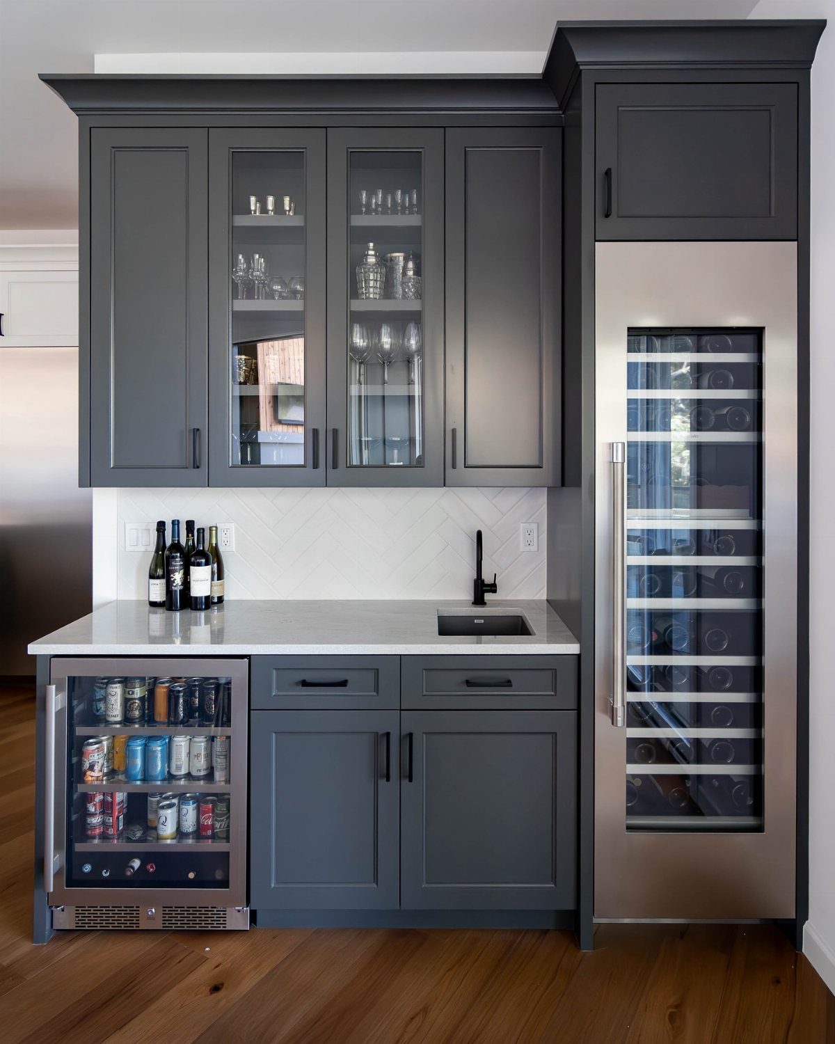Dark gray kitchen cabinets with a built-in beverage fridge and a tall wine cooler.