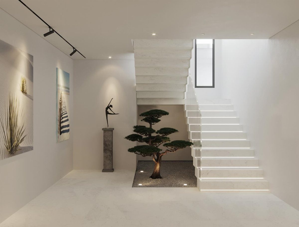 Minimalist white interior with a modern staircase, a small tree under the stairs, and simple wall art.