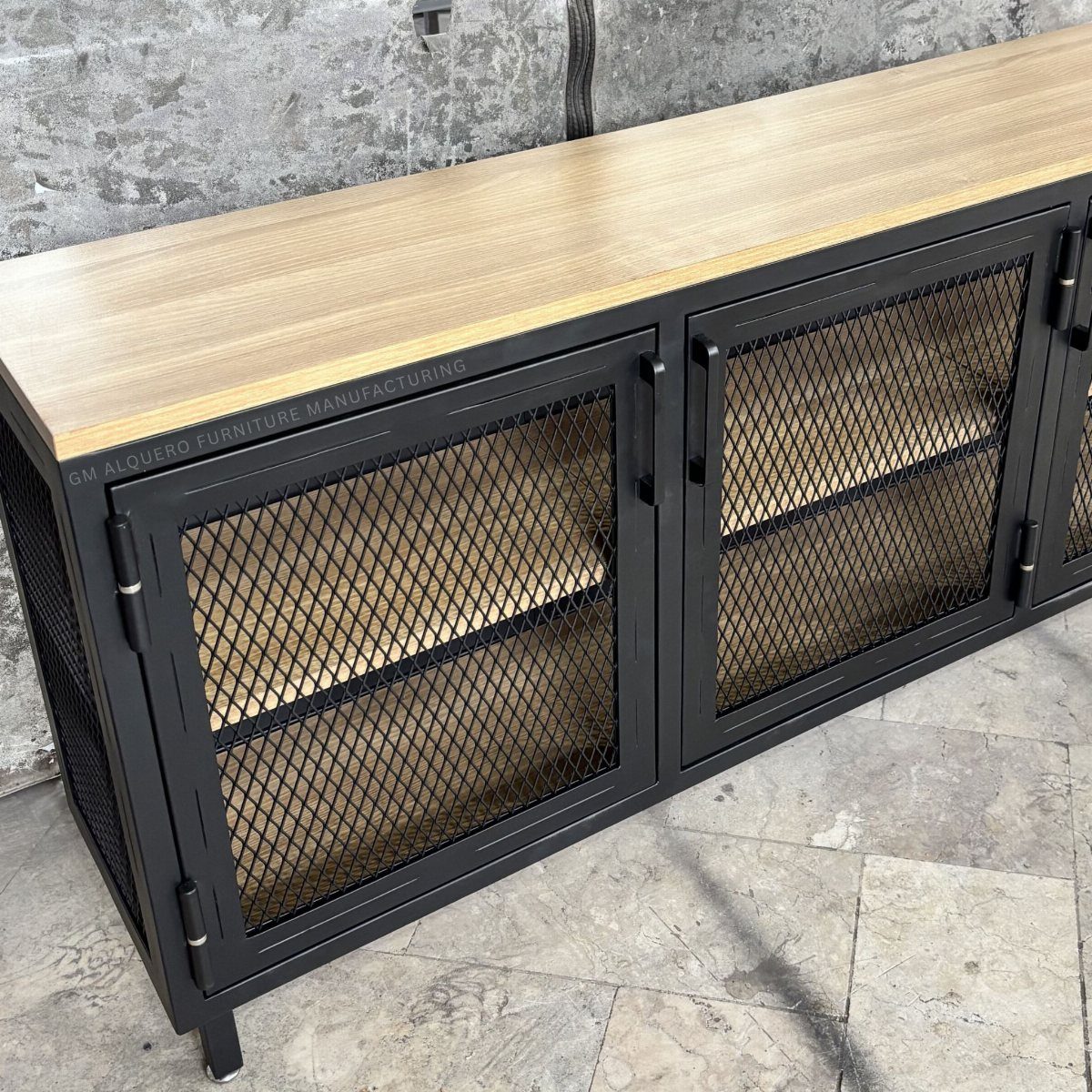 A long black metal sideboard with a light wood top and mesh cabinet doors.