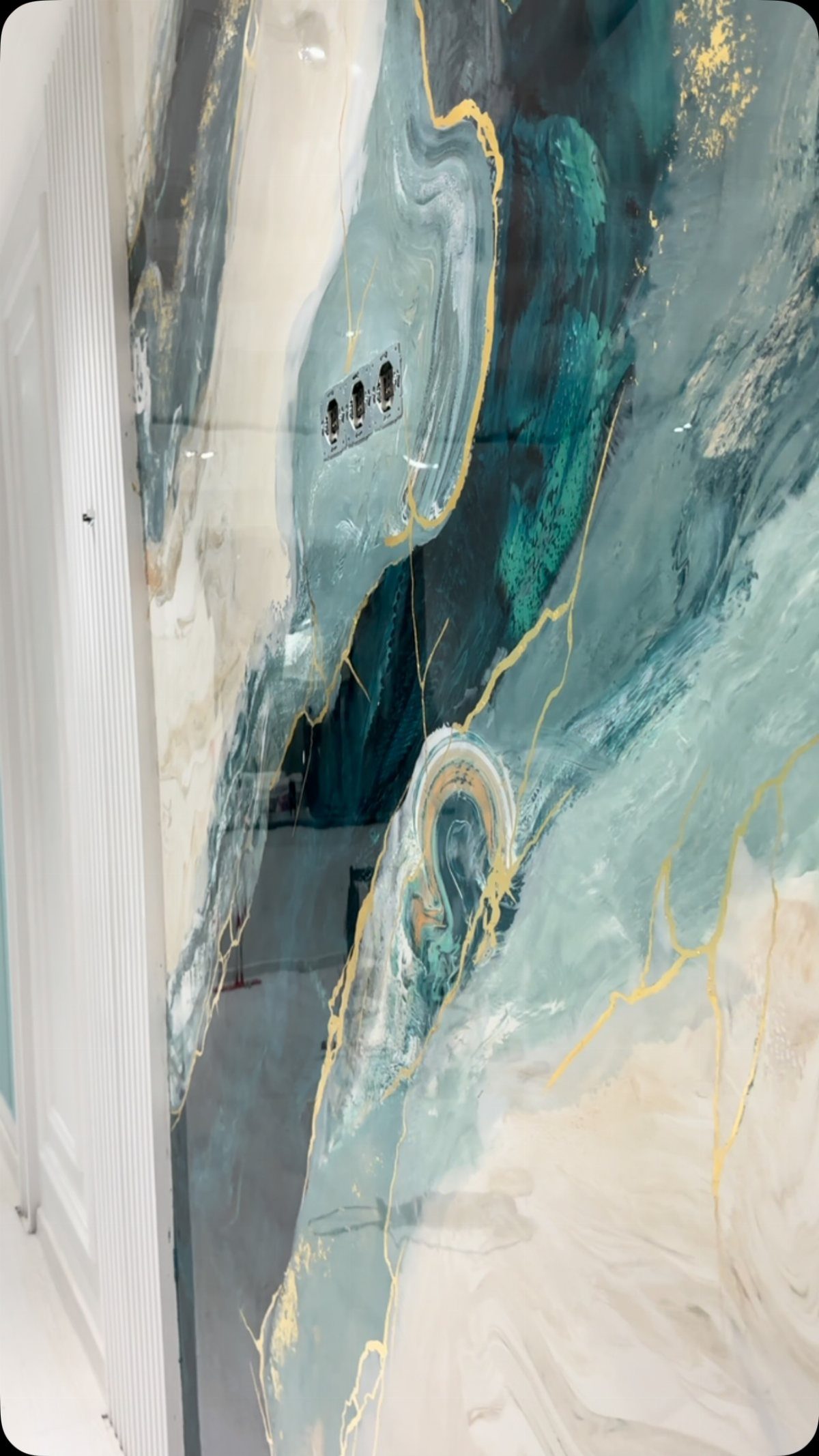 Glossy teal and white marble patterned surface with gold veins and integrated electrical outlets.