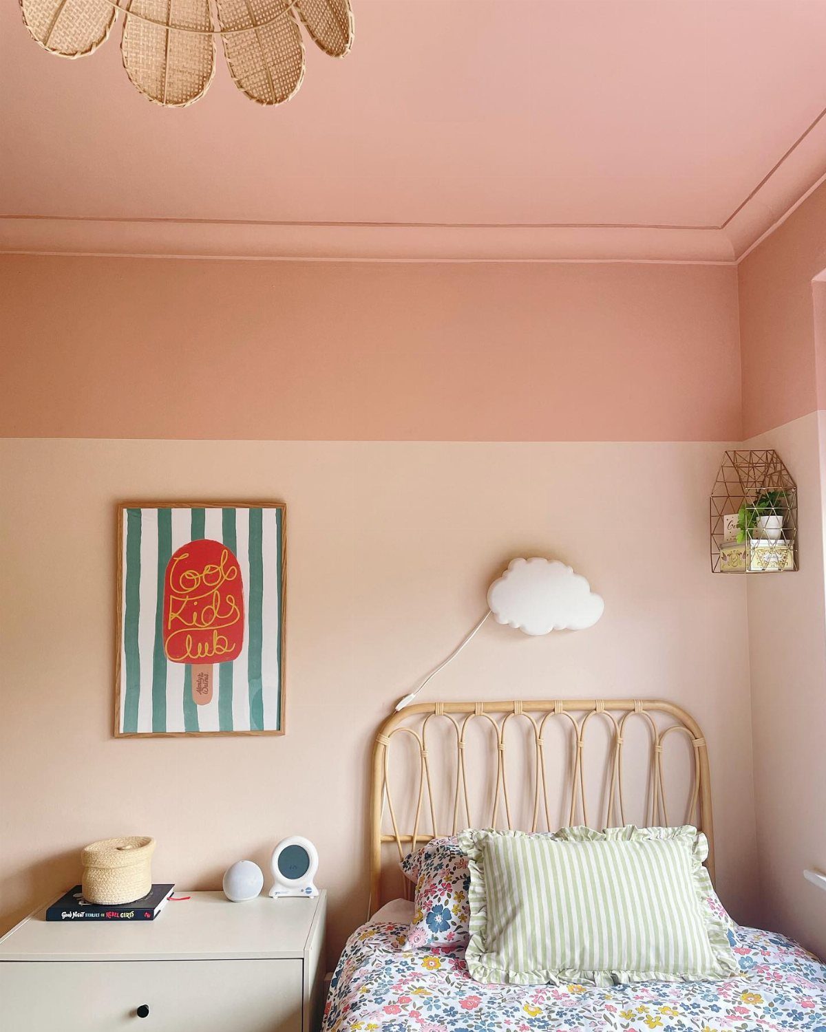 A bedroom featuring pink walls and a matching pink ceiling with a rattan headboard.