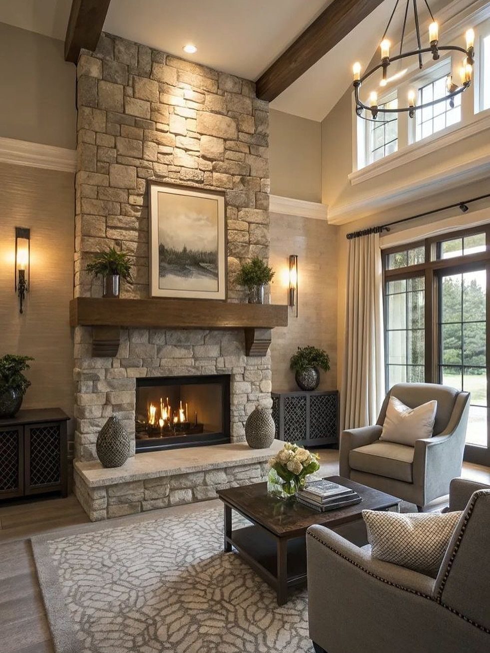 Stone fireplace with wooden mantel, grey armchairs, and beige window treatments in a living room.