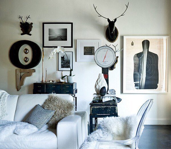 White sofa and acrylic chair arranged in a modern living room with black and white decor.