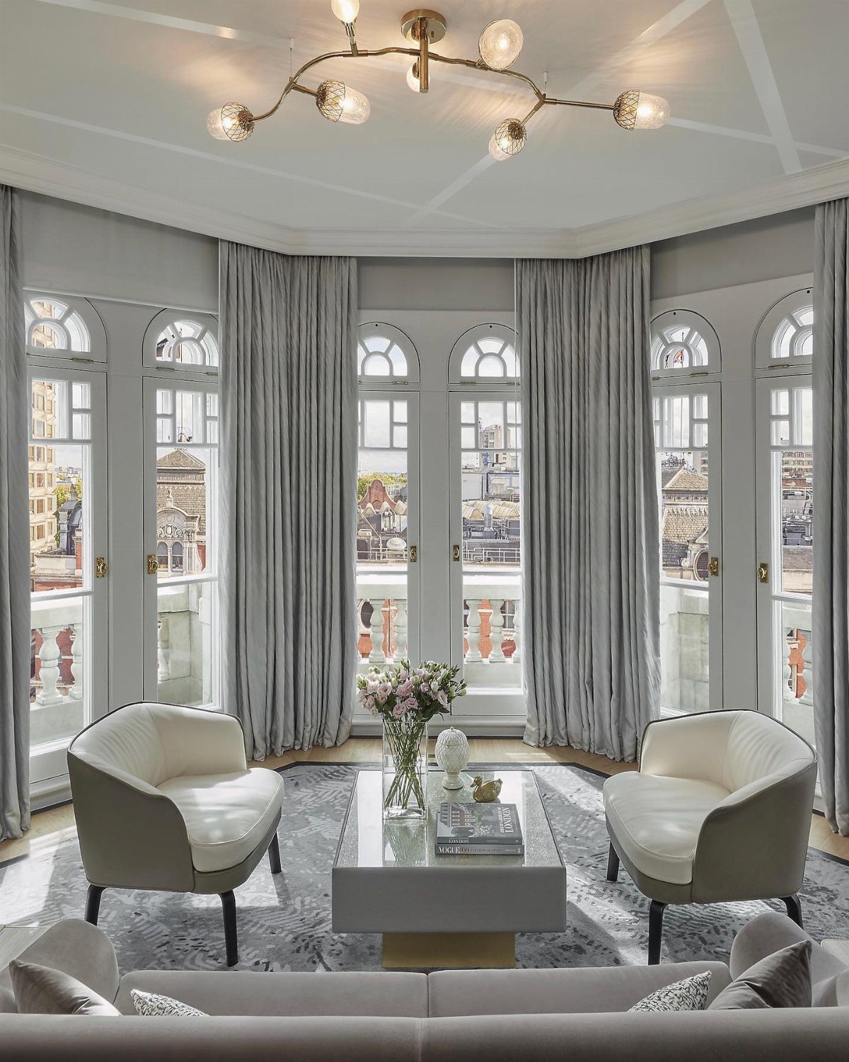 Grey armchairs and a coffee table arranged in a monochromatic grey living room.