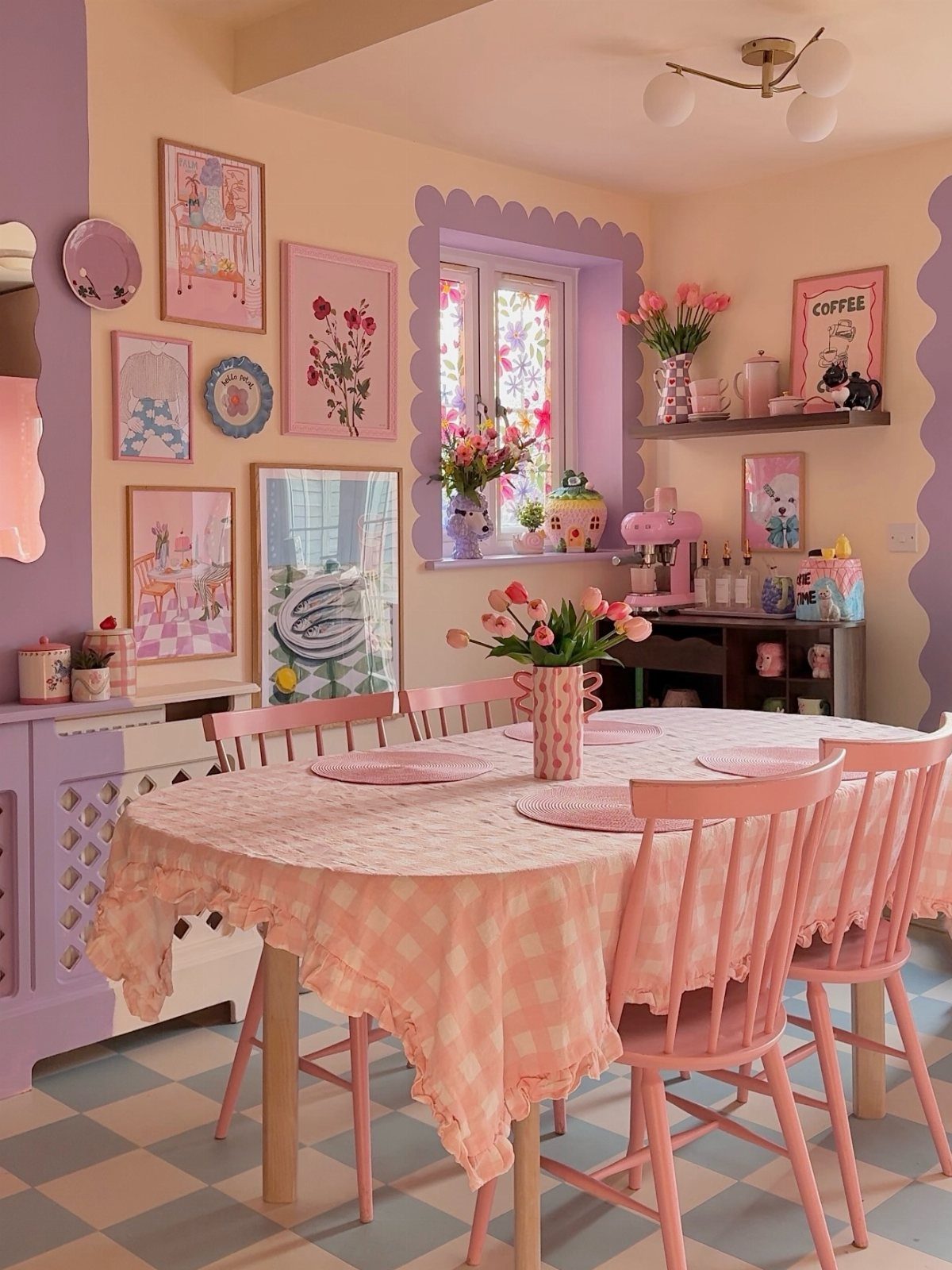Pink checkered tablecloth on a dining table surrounded by pink chairs and pastel decor.
