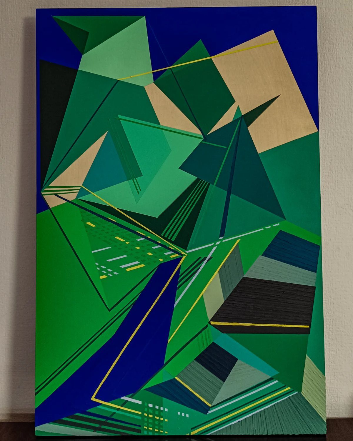 Abstract geometric painting with green, blue, and tan angular shapes.