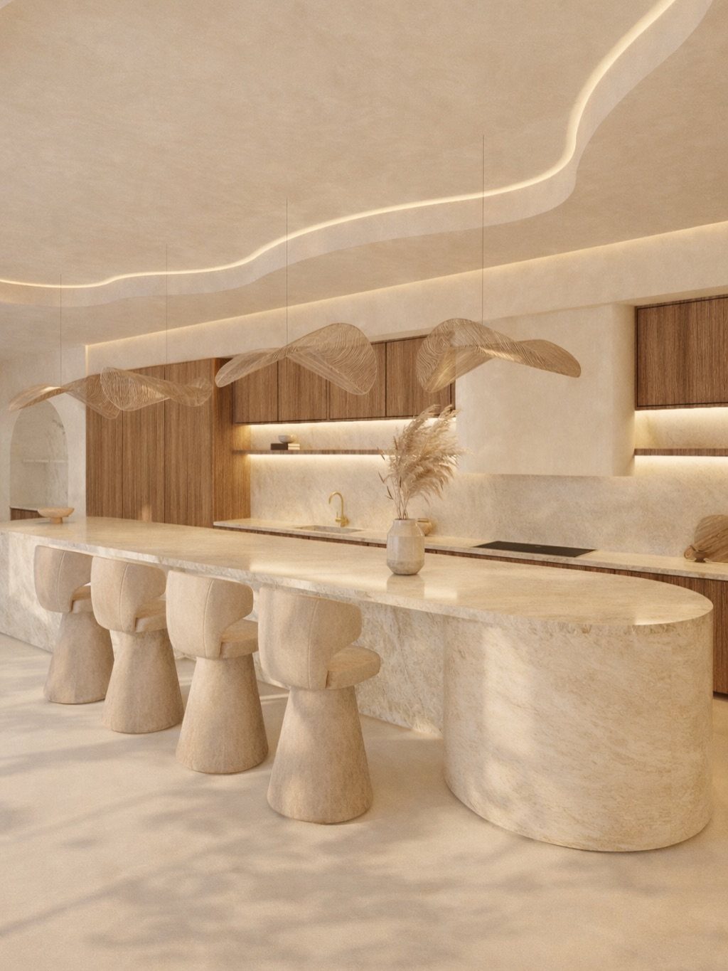 A minimalist kitchen with a large curved stone island, sculptural stools, and warm wood cabinetry.