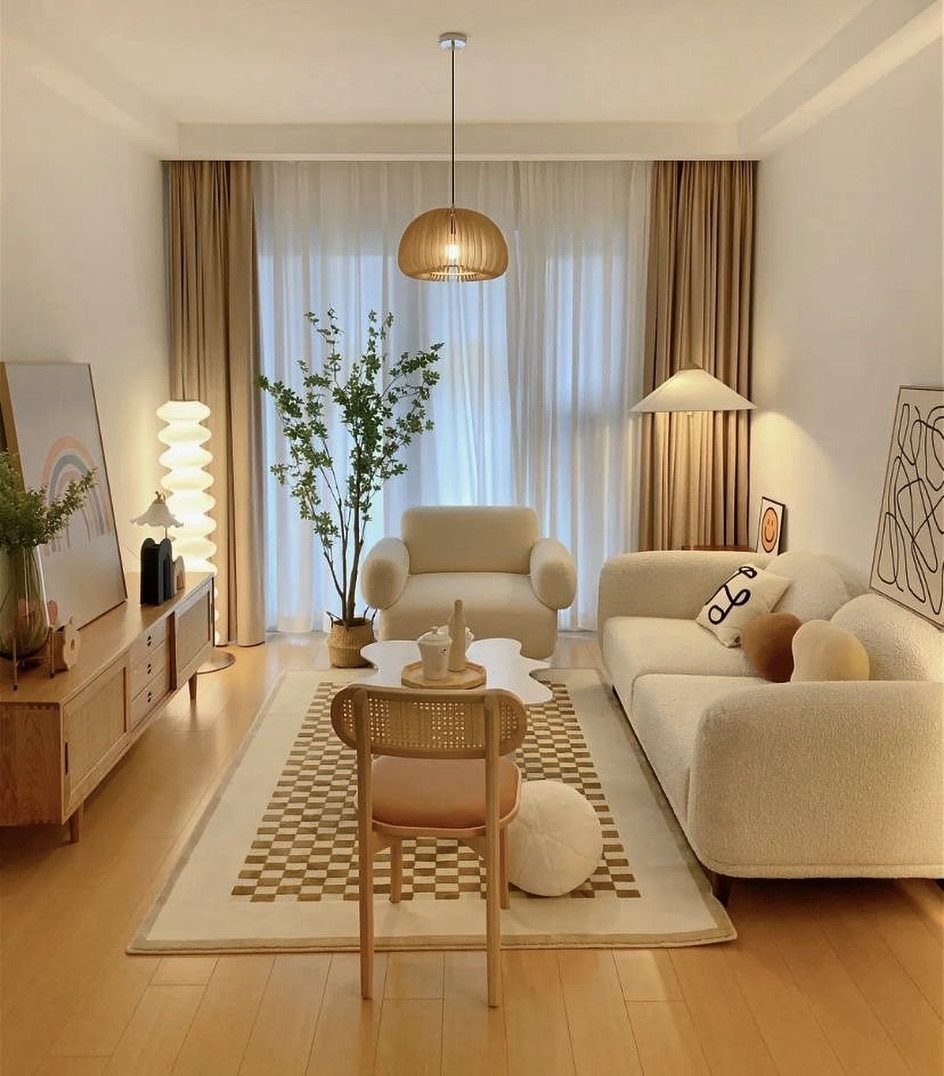 Cream colored furniture and wooden accents in a bright, modern living room with large windows.