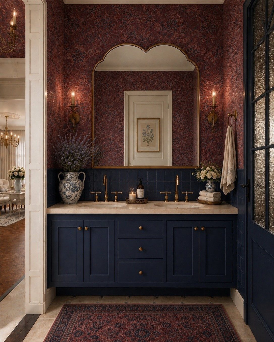Navy blue vanity with marble top and red patterned wallpaper in a moody room.