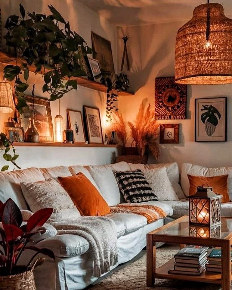 A cozy living room with a white sofa, wicker lamp, and lush green plants.