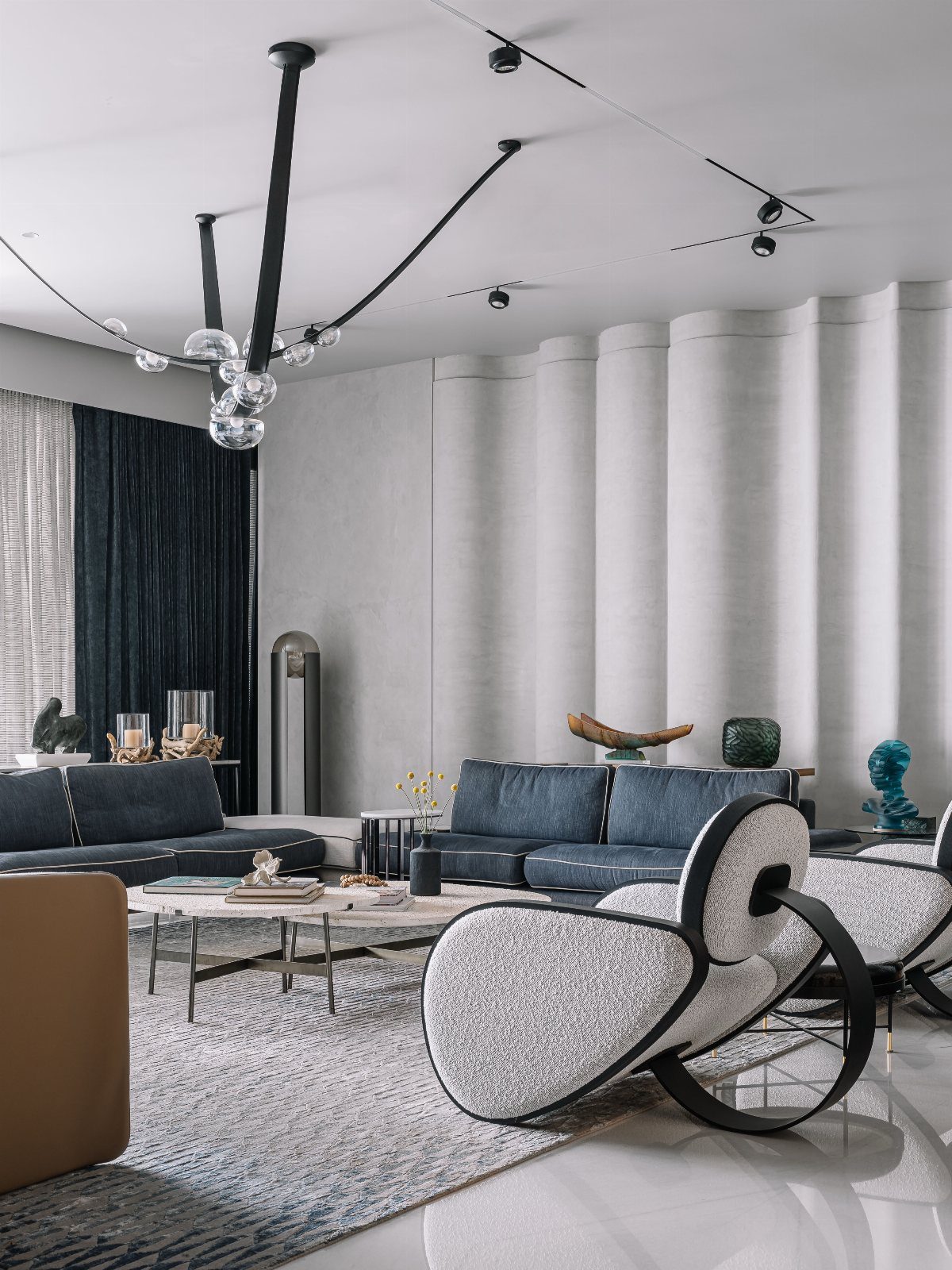 Textured grey patterned rug under modern blue sofas and a patterned armchair in a bright room.