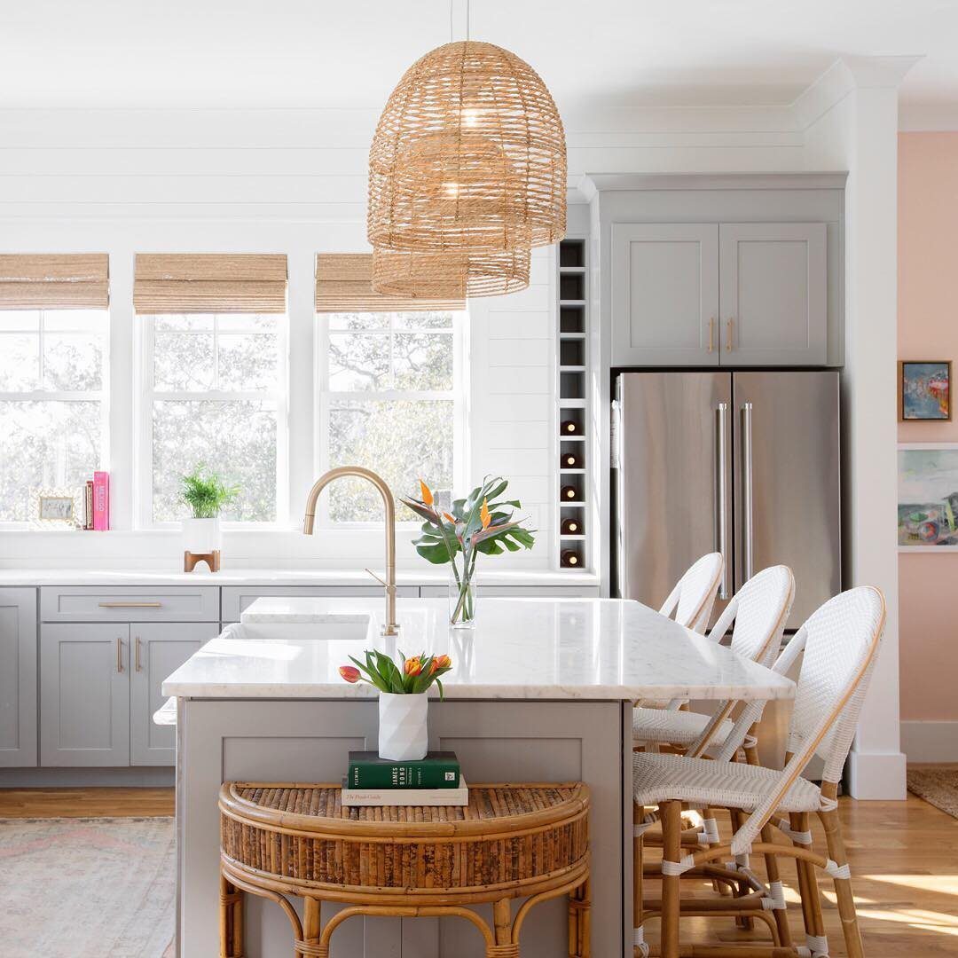Rattan pendant lights and a woven bench in a bright, modern kitchen setting.