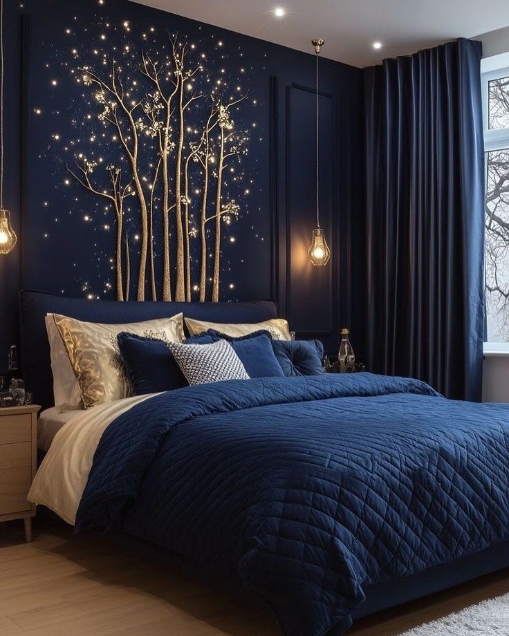 A navy blue bedroom with quilted bedding and a gold tree mural on the wall.