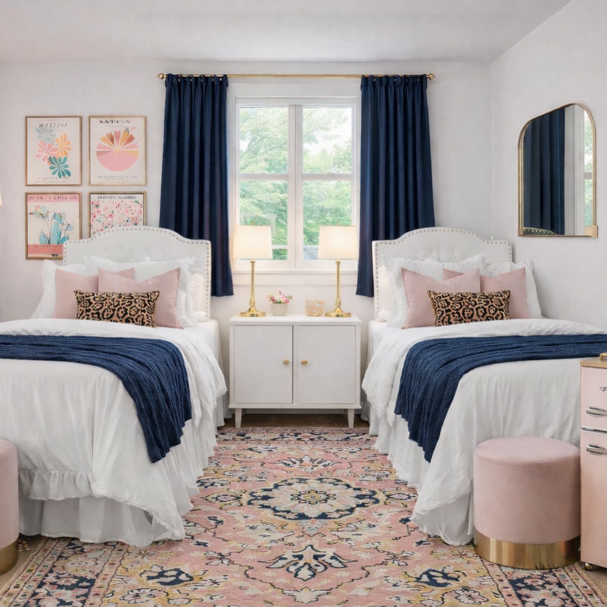 Two twin beds with navy throws and pink accents in a bright bedroom.