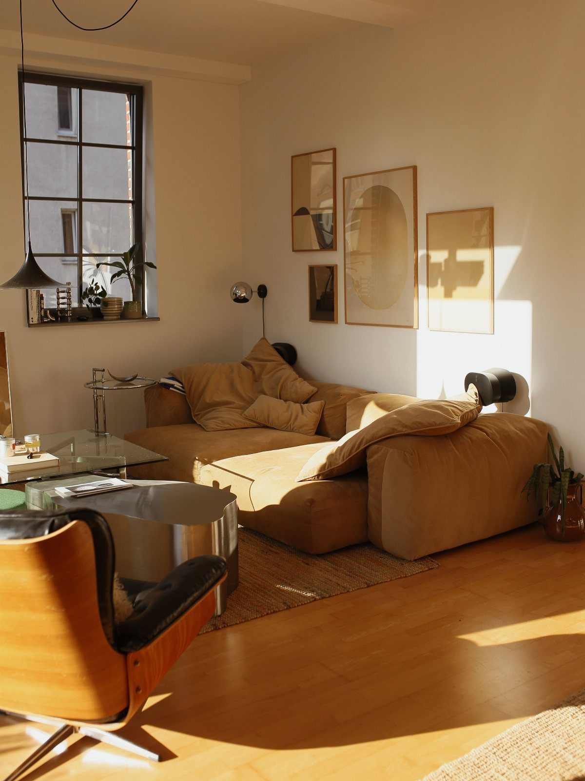 Plush tan sofa with soft pillows in a sunlit neutral living room setting.