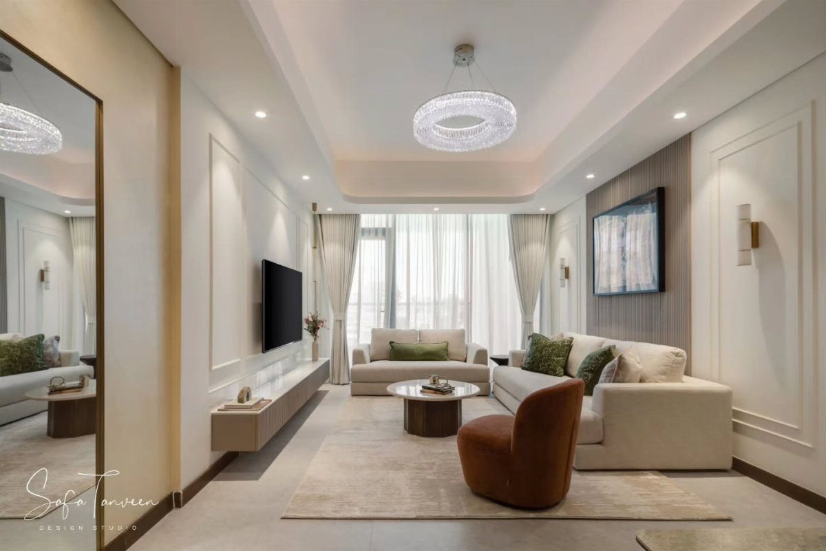 Neutral living room with cream sofas, a brown armchair, and a crystal chandelier.