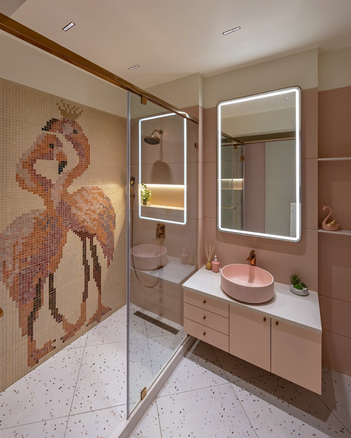 Pink floating bathroom vanity with a vessel sink and a flamingo mosaic shower wall.