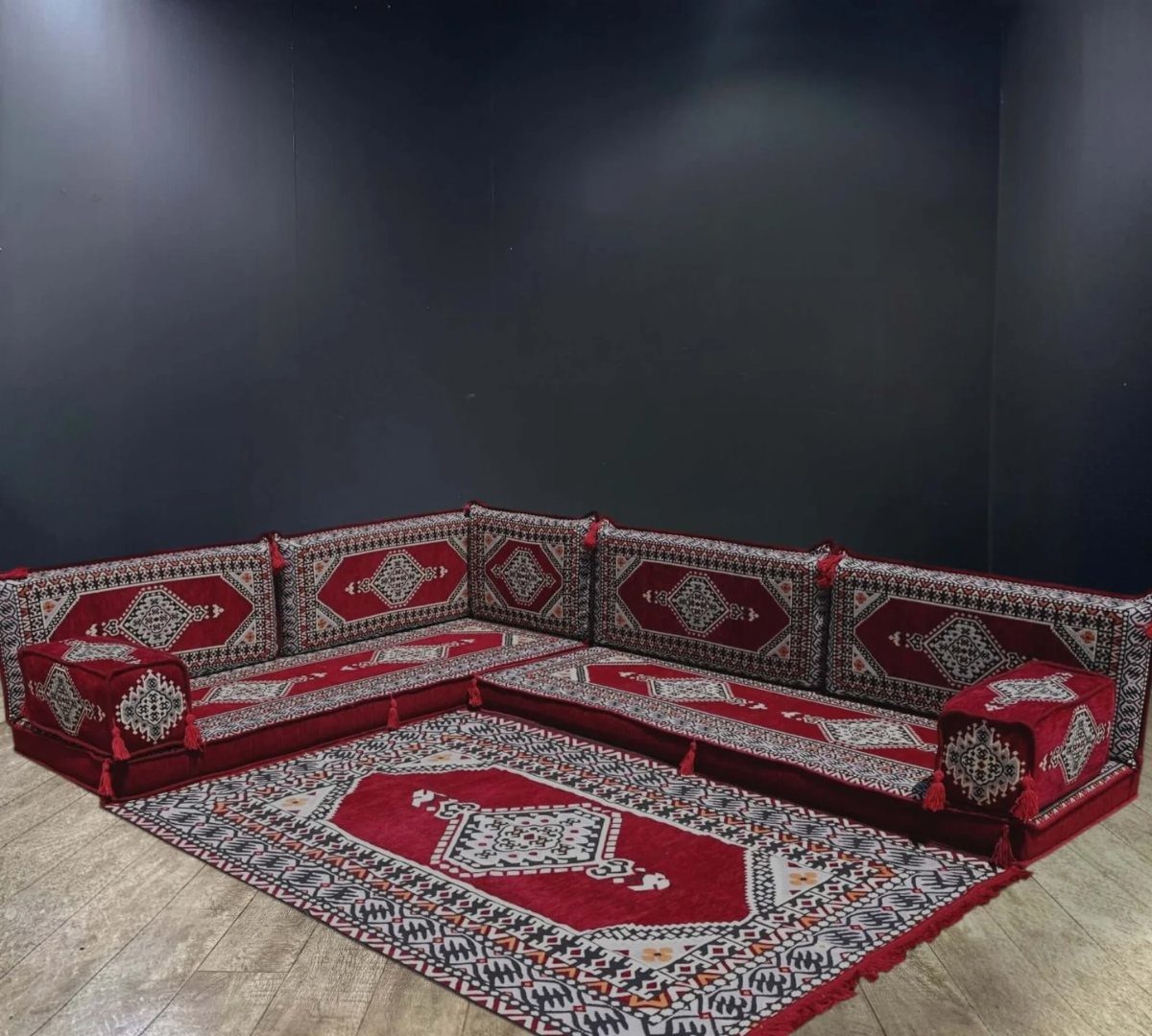 Red and white patterned floor cushions and a matching rug arranged in an L-shape.