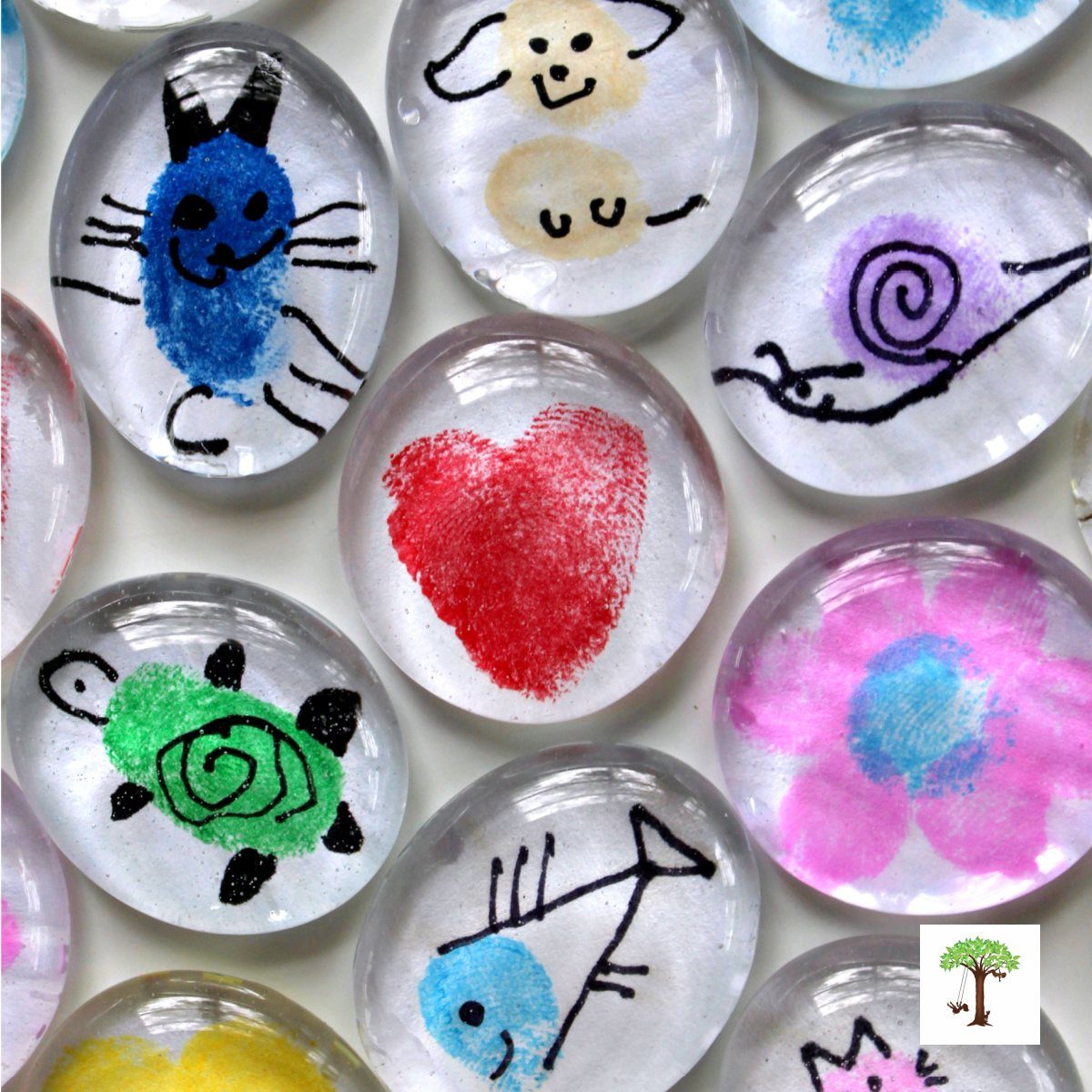 Clear glass pebbles decorated with colorful fingerprint art of animals and shapes.