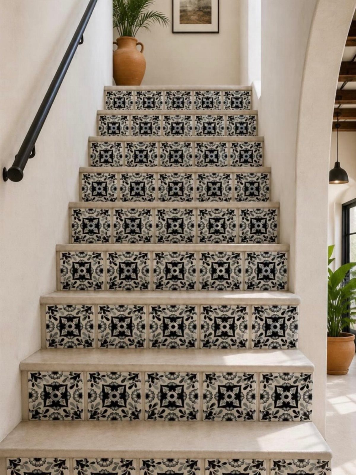 Staircase featuring decorative black and white patterned tiles on the risers against white walls.
