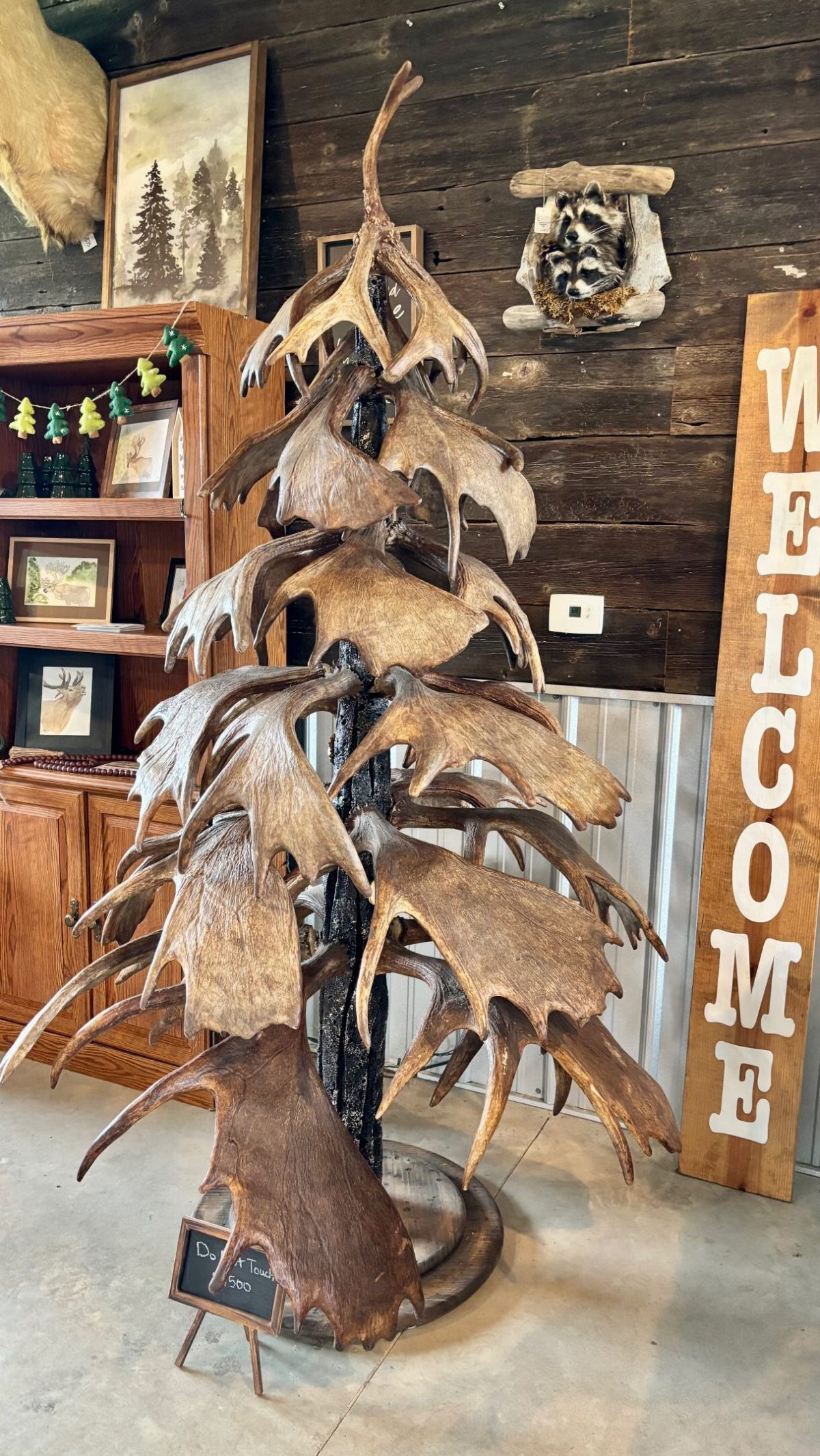 A large decorative sculpture made of many brown antlers arranged in a tree-like shape.