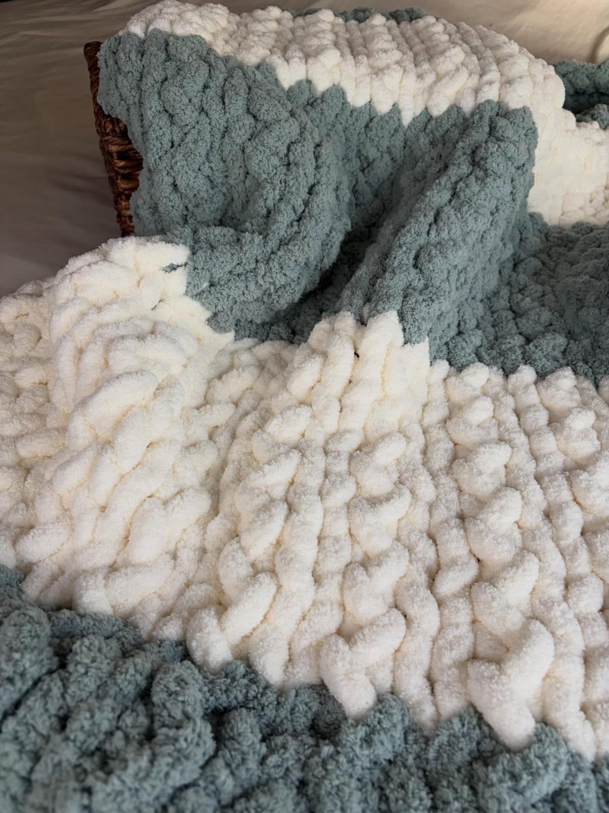 Thick cream and sage green chunky knit blanket with heavy texture.