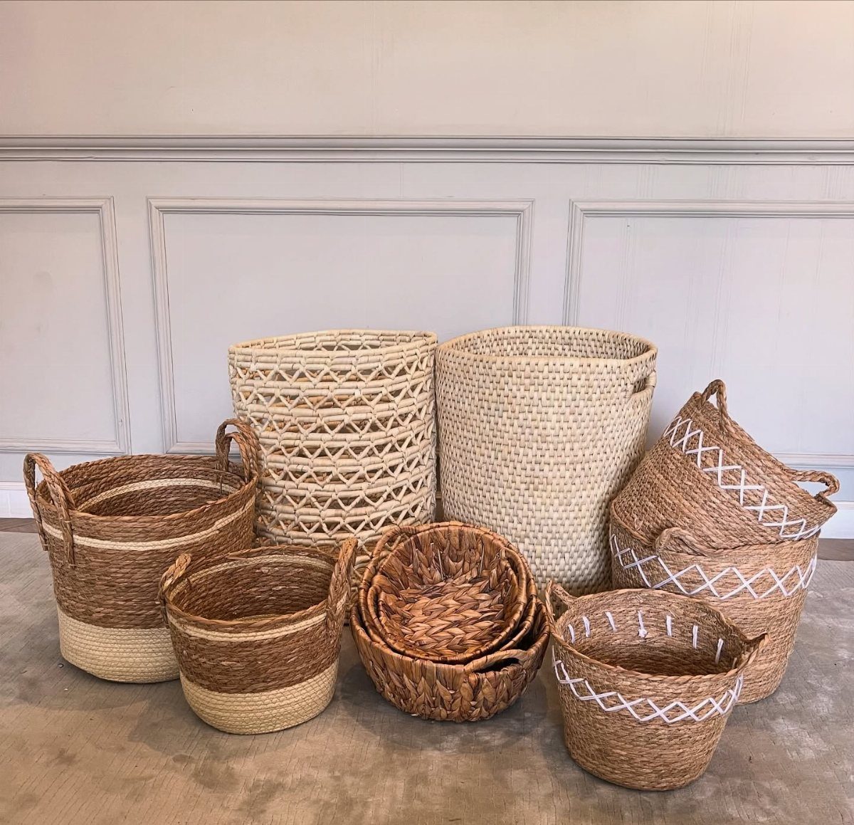 Various wicker and rattan storage baskets in different sizes and natural colors arranged on the floor.