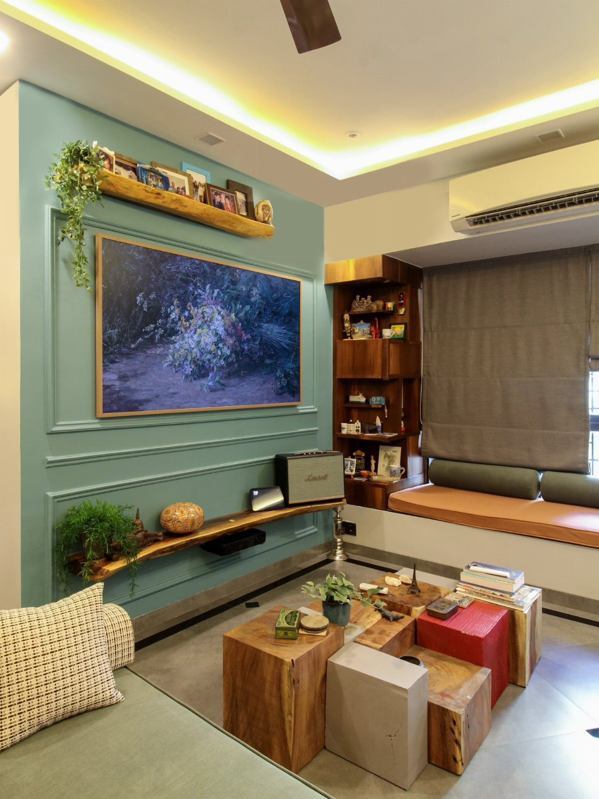Sage green paneled accent wall featuring a large landscape painting and wooden floating shelves.