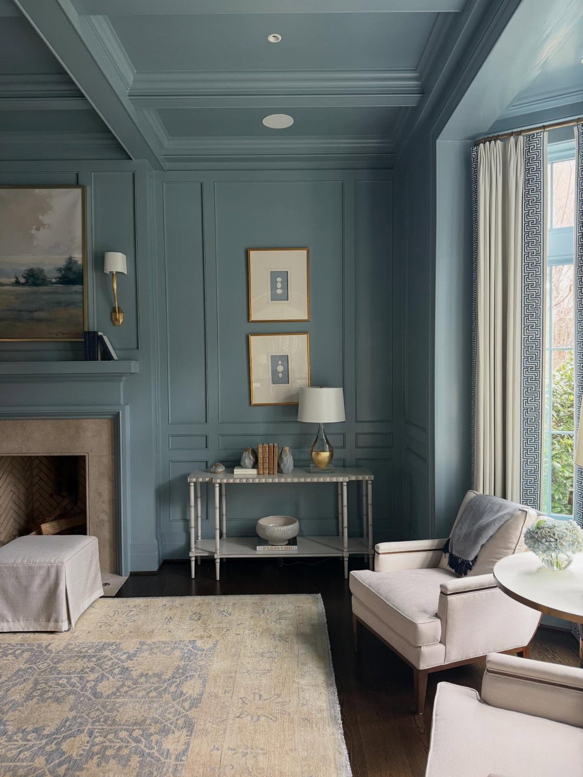 Blue-grey walls, ceiling, and paneling create a monochromatic color drenched room.