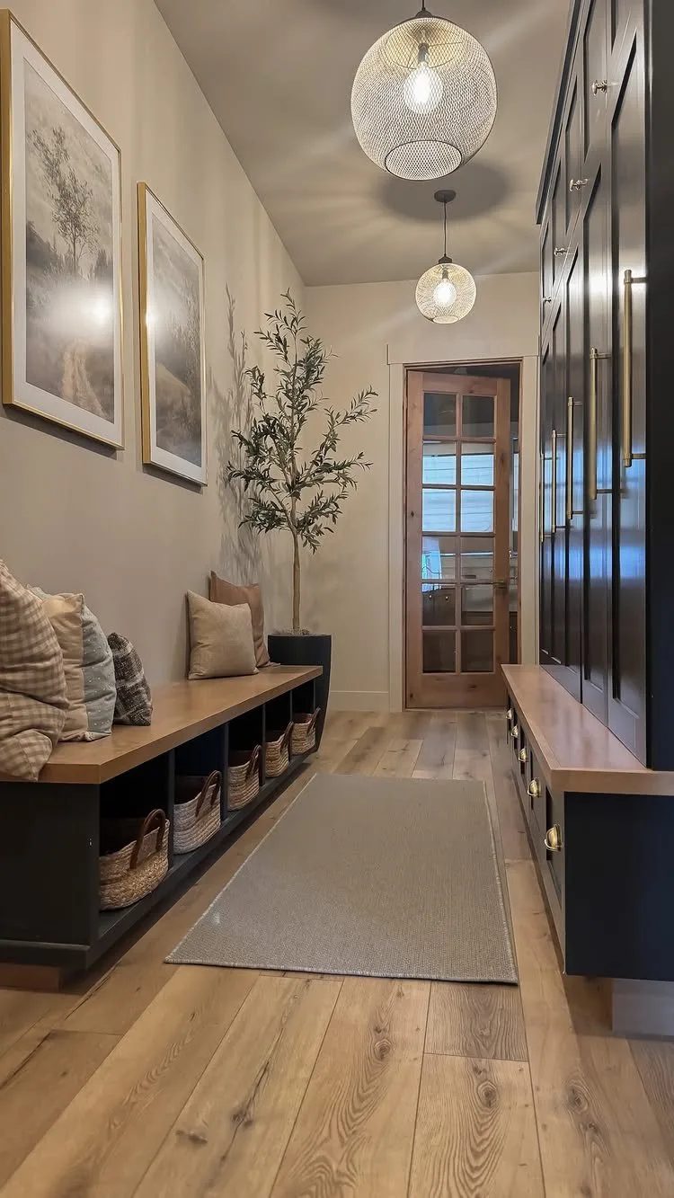 Grey rectangular rug on light wood flooring in a narrow mudroom hallway.