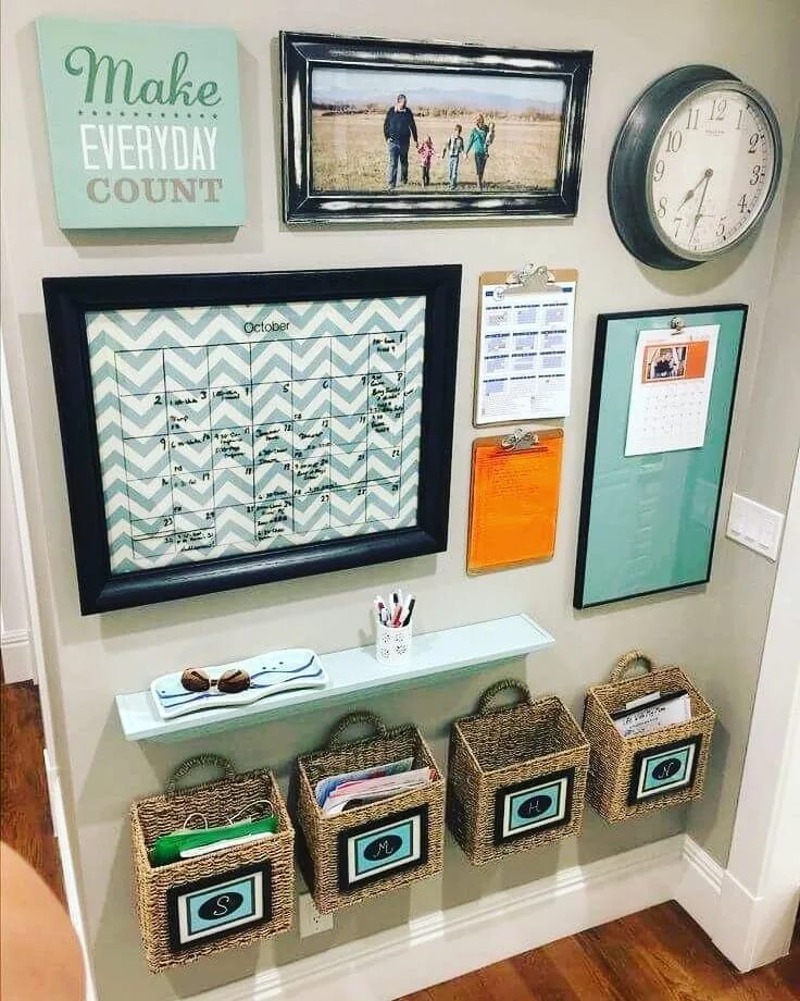 A wall-mounted family organization system with a large calendar, clipboards, and teal boards.