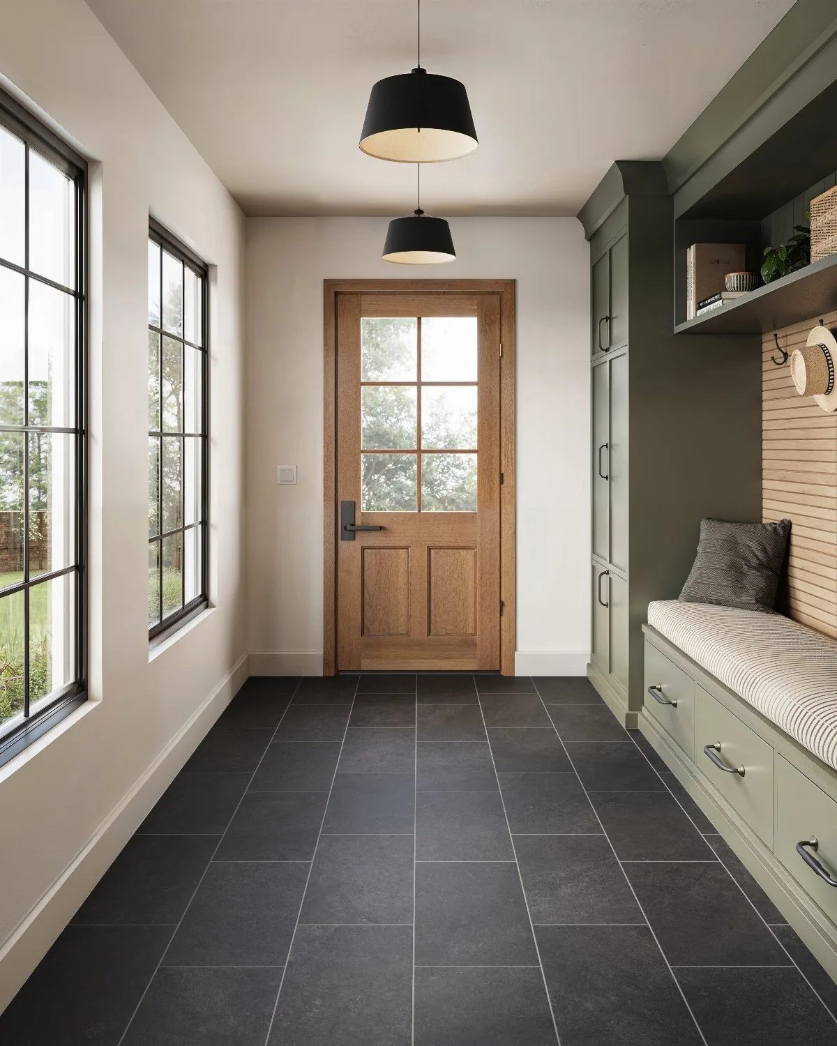 Dark grey rectangular tiles cover the floor of a bright, modern mudroom entryway.