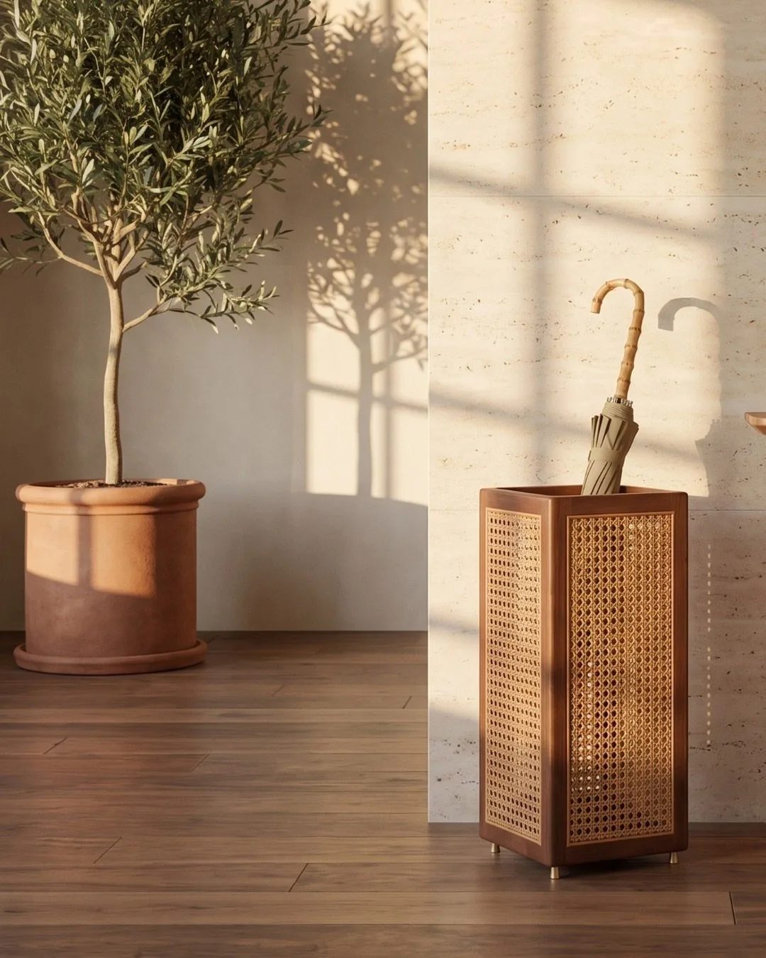 A tall woven cane umbrella stand holding a single umbrella against a light wall.
