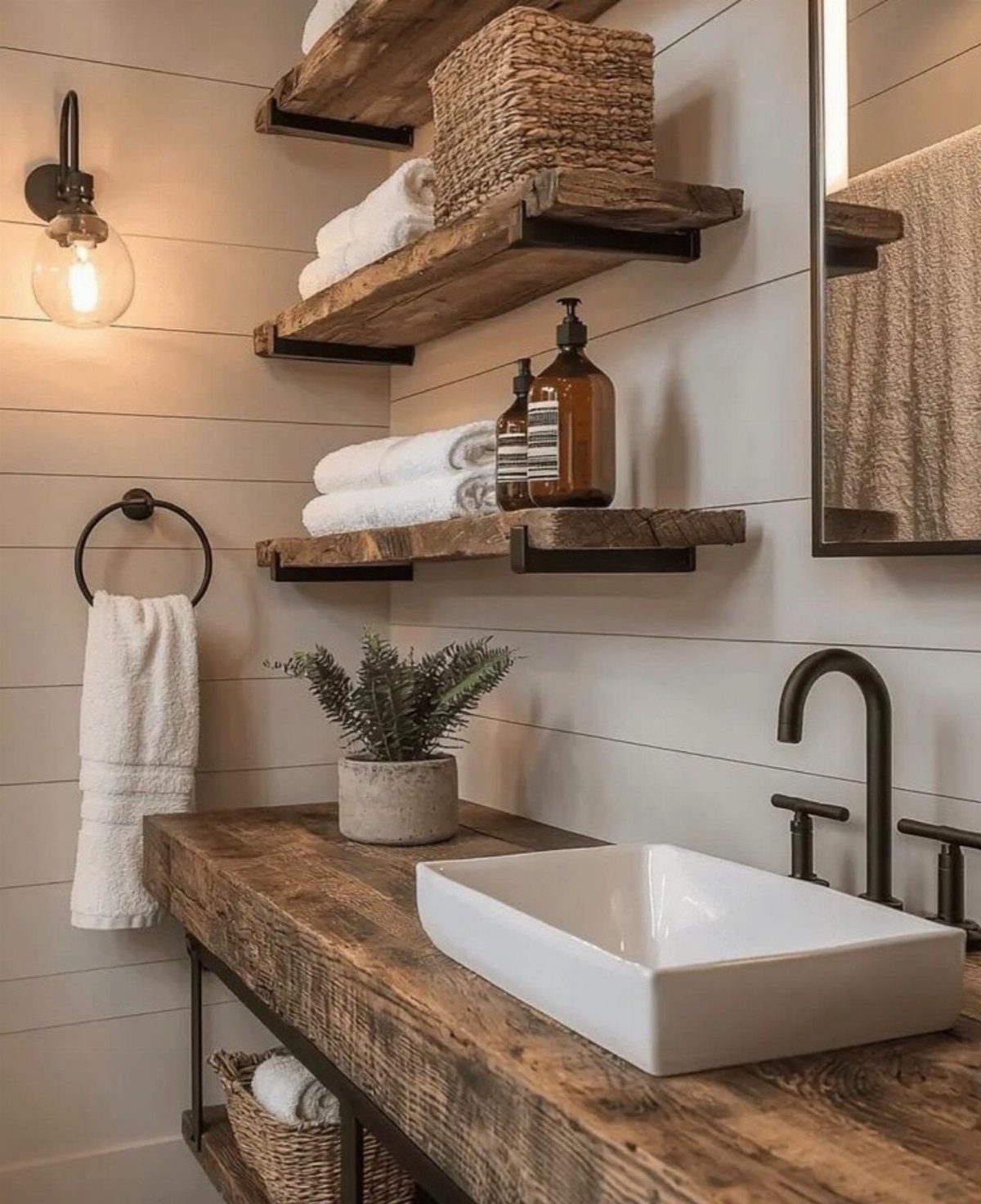 Rustic wooden bathroom vanity with a white vessel sink and floating wood shelves against shiplap walls.