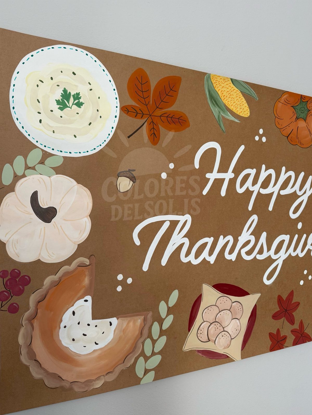 Hand-painted brown triangular banner with Thanksgiving food illustrations and Happy Thanksgiving text.