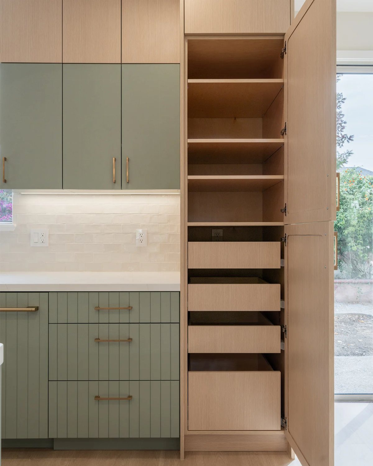 Tall narrow light wood cabinet with open door showing interior shelves and drawers.