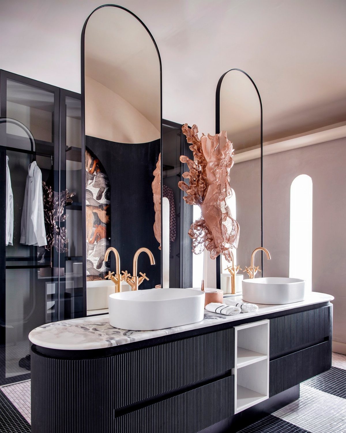 Contemporary bathroom with dark ribbed vanity, white vessel sinks, gold faucets, and large arched mirrors.