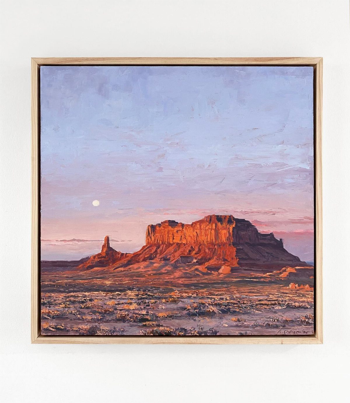 Framed landscape painting of a desert mesa under a sunset sky with a small moon.