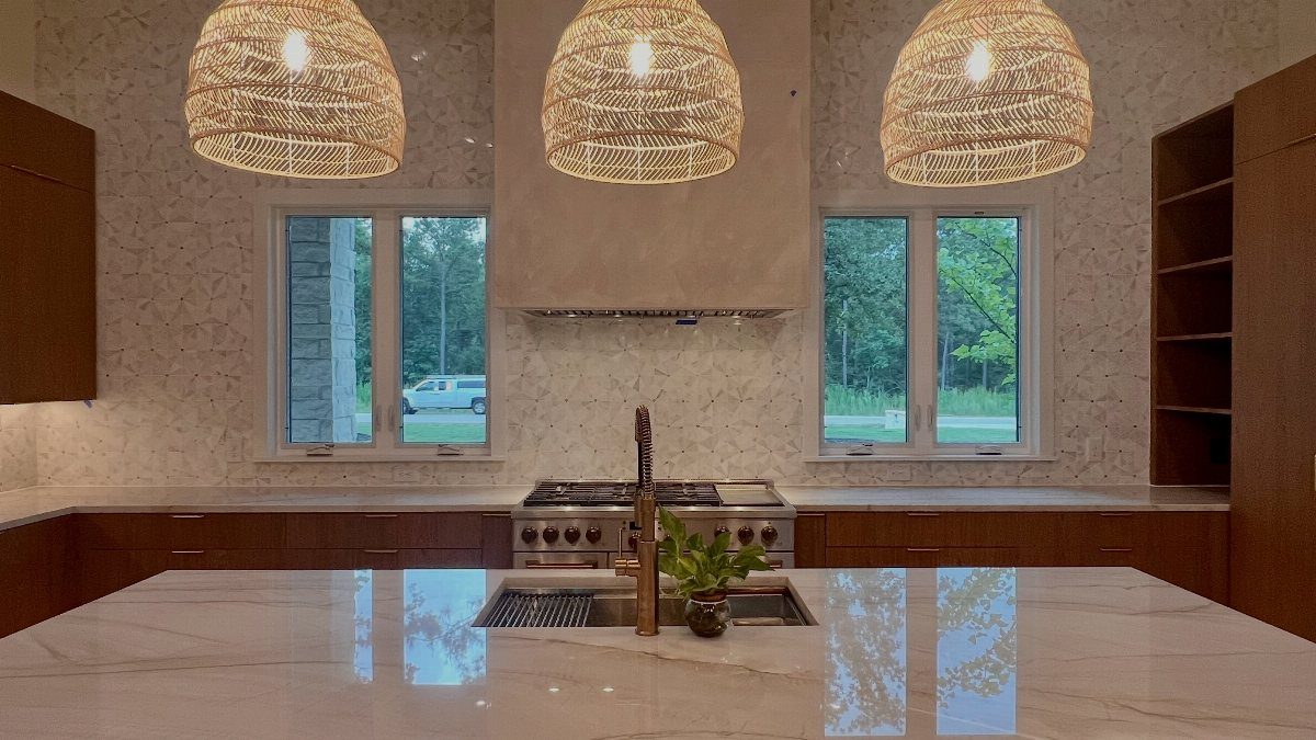 Large white sculptural range hood above a stove in a modern kitchen with wood cabinets.