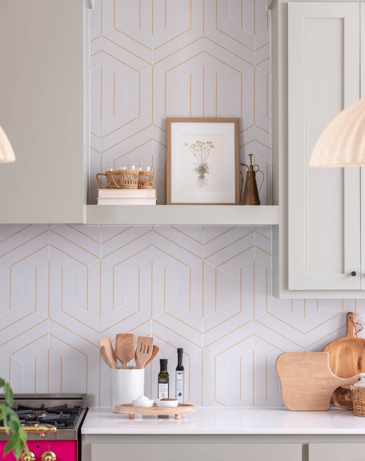 Geometric patterned backsplash with gold outlines in a bright white kitchen setting.
